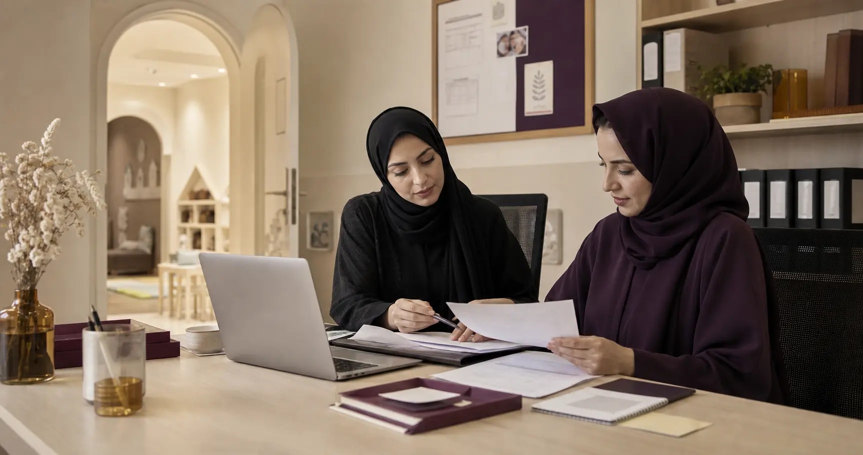 Two nursery operations colleagues reviewing organised staff and finance records
